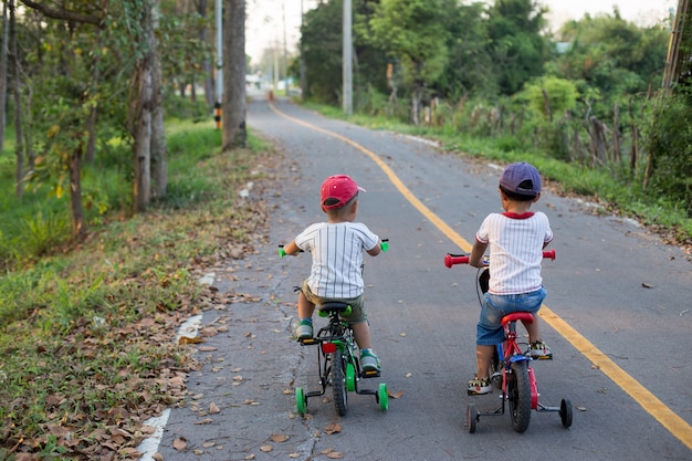 The two lovely boys are riding bike on the bike laen.