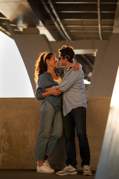 Two lovers kiss at sunset happy stylish couple embrace lovely young man and woman hug in sunlight