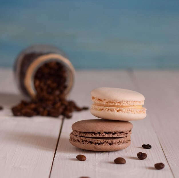 Two macaroons with coffee on the wood table