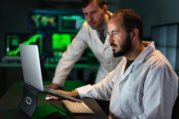 Two male doctor colleagues analyze some experiment results in the laptop Working in laboratory