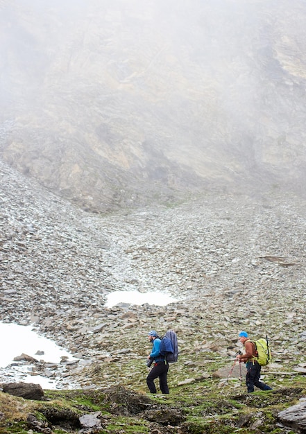 Two male travelers walking on mountain path