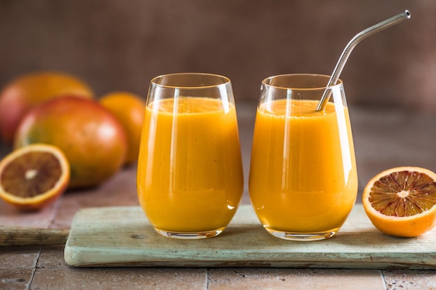 Two mango lassi or kesar milk in glasses Indian healthy ayurvedic cold drink with mango Freshness lassi made of yogurt water spices fruits and ice