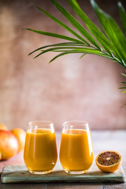 Two mango lassi or kesar milk in glasses Indian healthy ayurvedic cold drink with mango Freshness lassi made of yogurt water spices fruits and ice