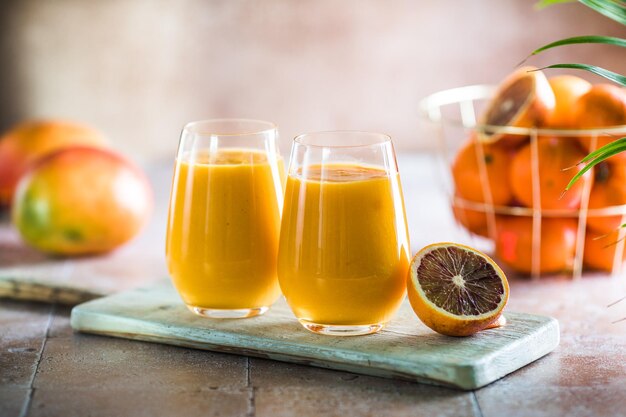 Two mango lassi or kesar milk in glasses Indian healthy ayurvedic cold drink with mango Freshness lassi made of yogurt water spices fruits and ice