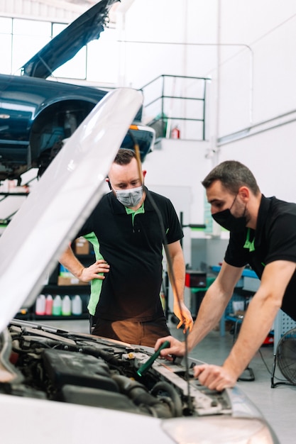 Two mechanic fixing car in auto repair shop