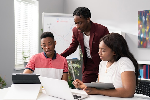 Two men and beautiful woman sit in an office in the morning preparing for work