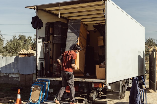 Two men loading a piece of furniture onto a moving truck