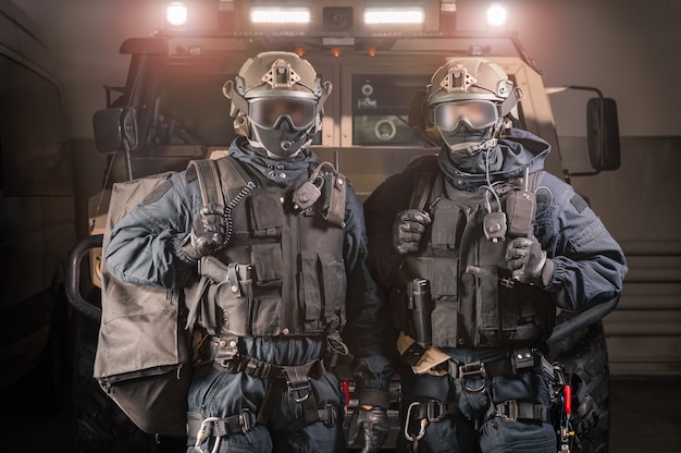 Photo two men in military uniforms stand in a hangar with a truck