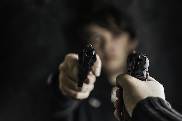 Two men point pistols at each other threat to life closeup of hand with weapon shootout of criminals...