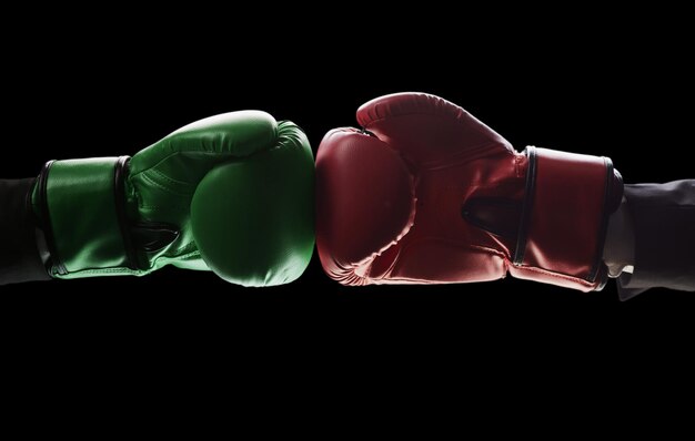 Two men's hands in boxing gloves The concept of confrontation Photo on a black background