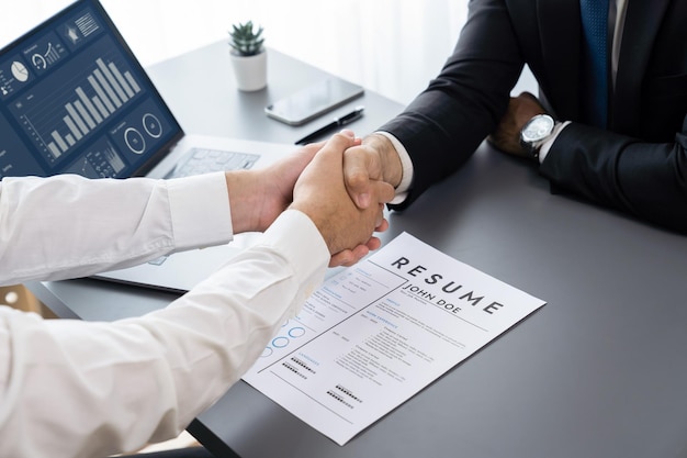 Two men shaking hands over a resume form.