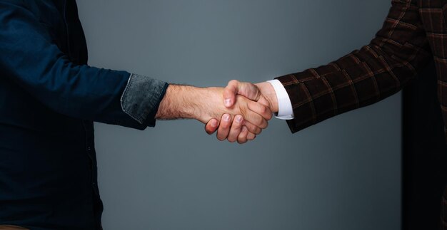 Two men shaking hands while standing next to each other A Symbol of Friendship and Agreement