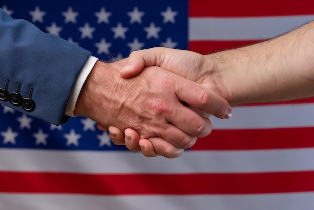 Two men shaking hands with the US flag Political protection of citizens in America Alliance with USA