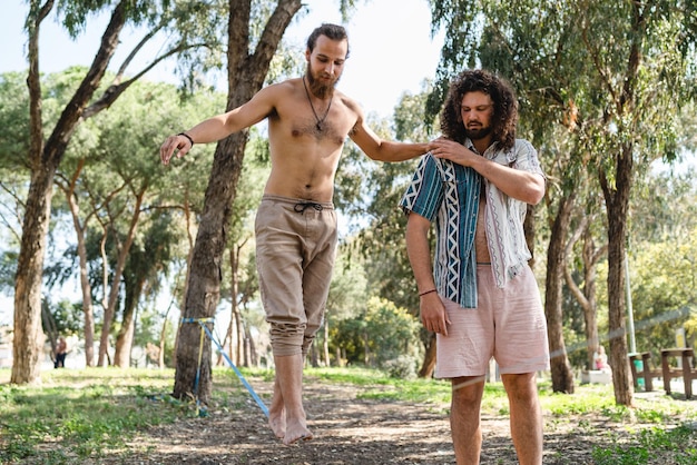 Two men slacklining in city park during summer day