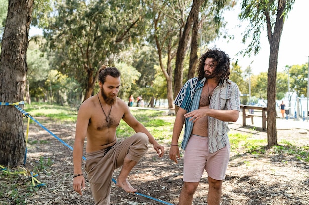 Two men slacklining in city park during summer day