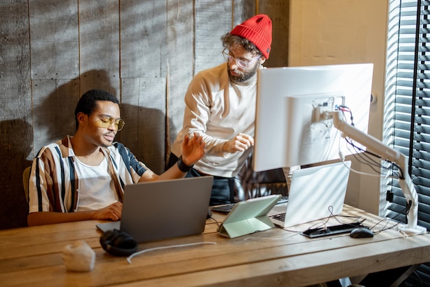 Two men working on computer at home office