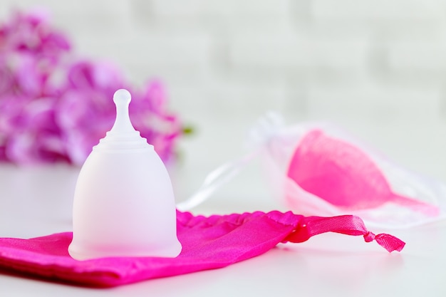 Two menstrual cups on table close up