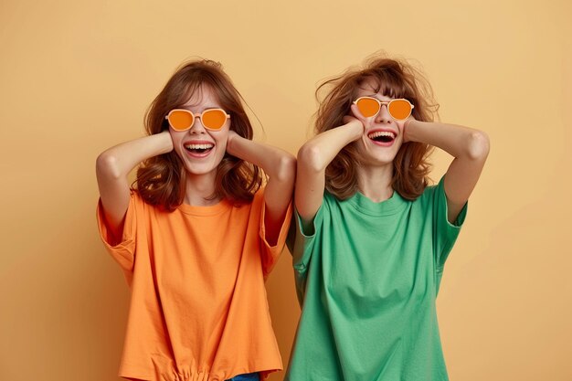 Photo a two modals girls wearing sunglasses and one wearing a green jacket orange background