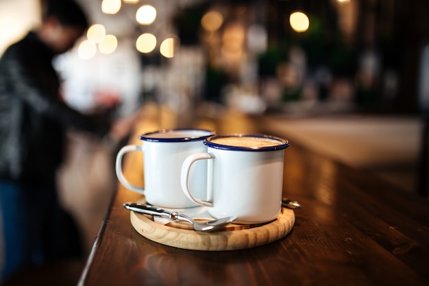 Two mugs with morning coffee on a wooden board