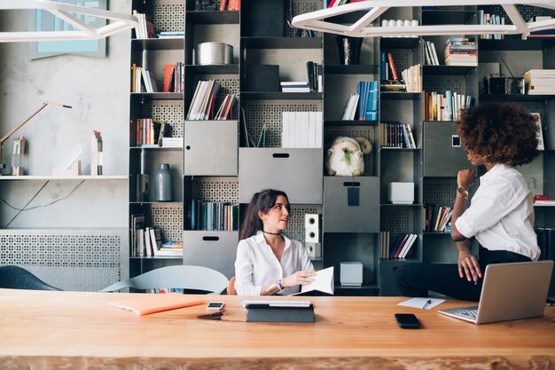 Two multiracial students discussing project in a co-working office 