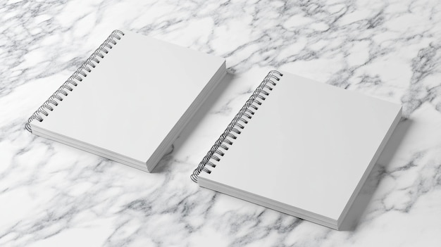 two notebooks are laying on a marble counter top