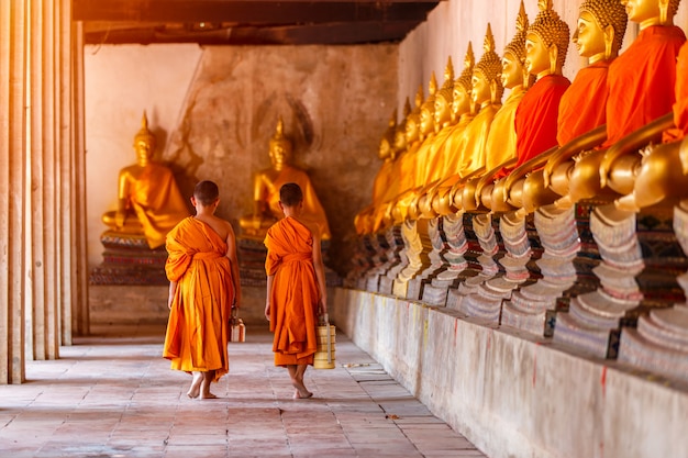 Two novices walking return and talking in old temple at sunset time, Ayutthaya Province, Thailand