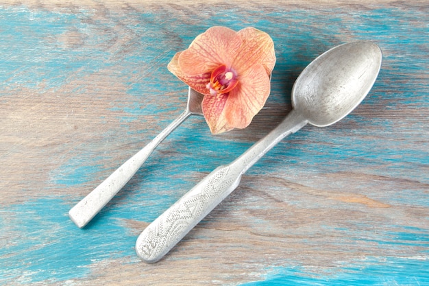 Two old aluminum spoons on blue wooden background. Copy space for text, food photography props.