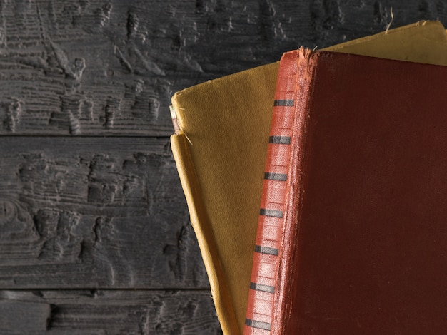 Two old books on a black rustic table. Retro writing paper. 