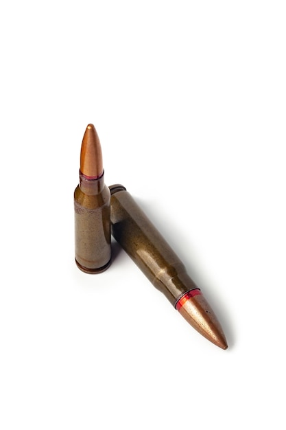 Two old bullets for automatic rifles of 545 and 762 caliber on a white background Selective focus