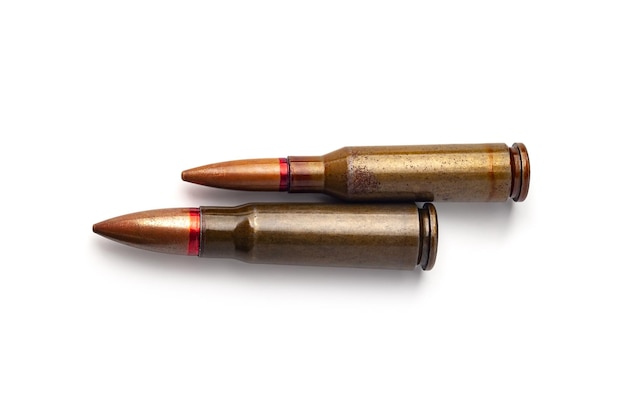 Two old bullets for automatic rifles of 545 and 762 caliber on a white background Selective focus