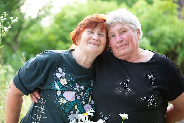 Two older women friends hugging and looking at the camera