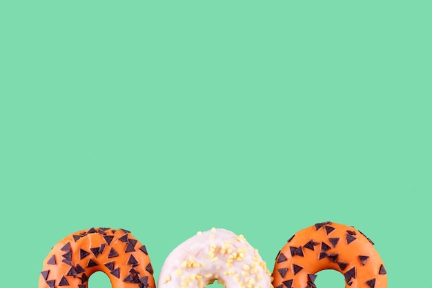 Two orange donuts and one white on an blue background Space for text