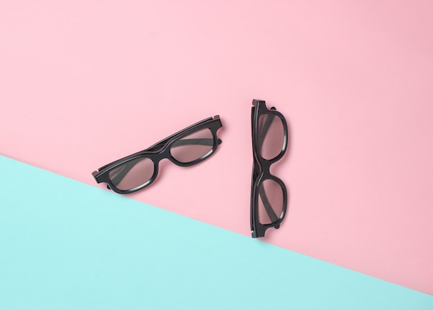 Two pairs of 3d glasses on a pink blue pastel surface. Top view. Minimalism