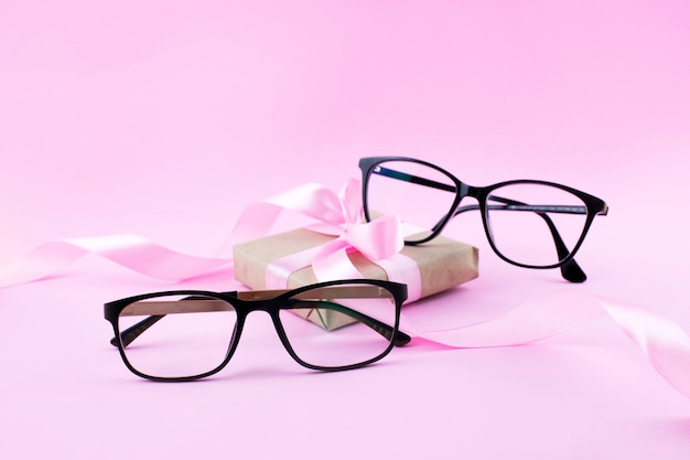 Two Pairs Of Black Eyeglasses  On Pink surface