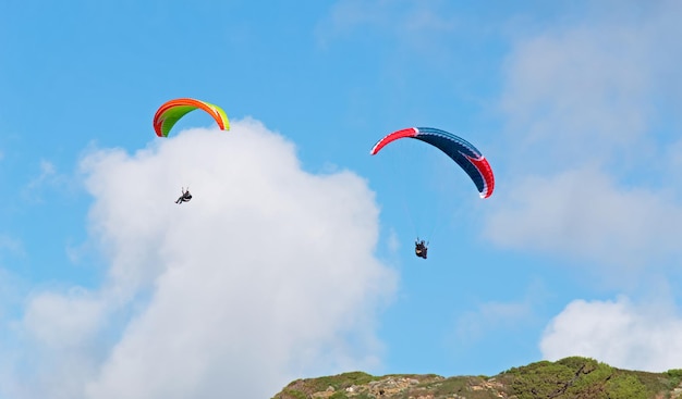 Two para gliders flying on a cloudy day