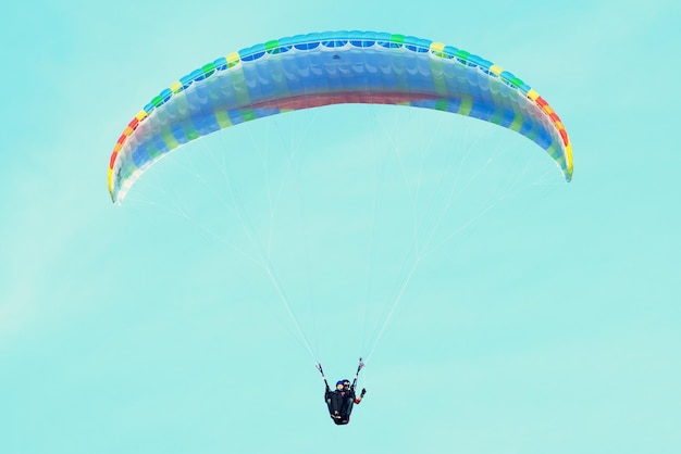 Two people are flying on a paraglider in the sky