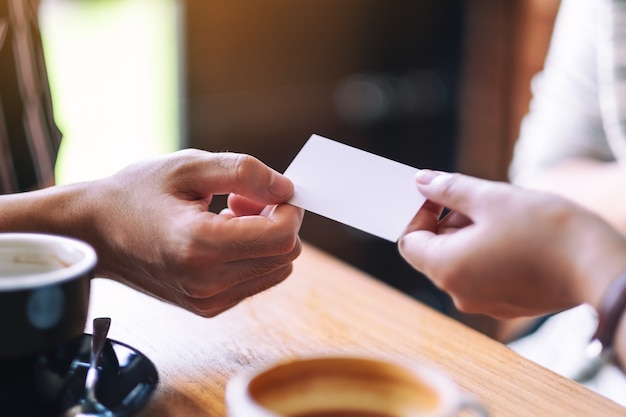 Two people holding and exchanging empty business card