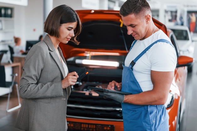 Two people Man repairing woman's automobile indoors Professional service