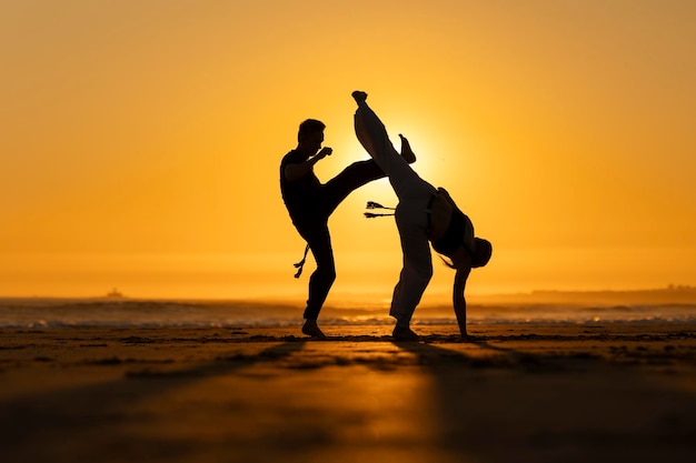 Photo two people practicing capoeira martial arts at sunset on the beach