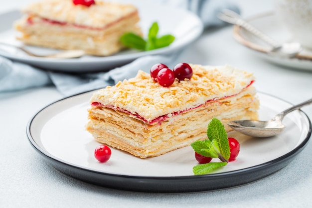 Two pieces of cake Napoleon on white plate Russian cuisine multi layered cake with pastry cream close up view