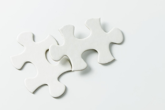 Two pieces of white jigsaw puzzle