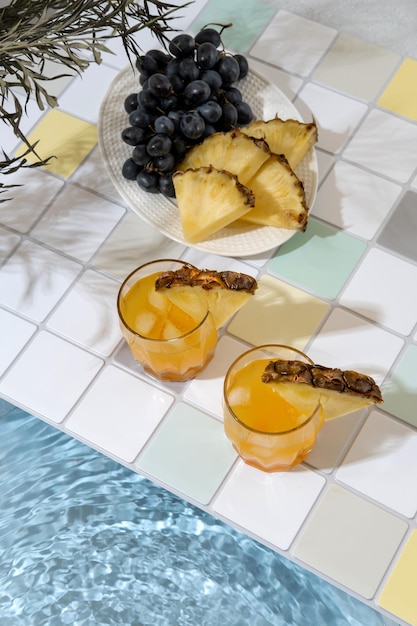 Two pineapple cocktail on edge of swimming pool Summer vacation and travel concept Exotic summer drinks