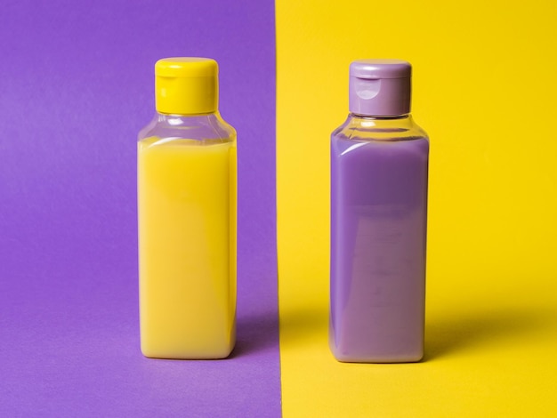 Two plastic bottles with a yellow and lilac product on a twocolor background