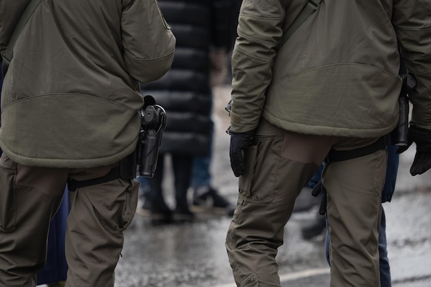 Two police officers stand on a street in front of a crowd.