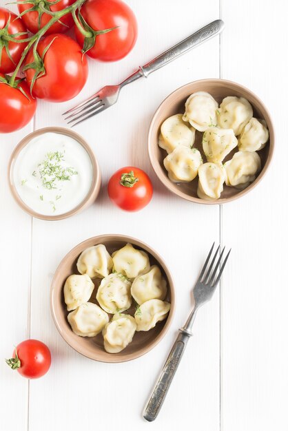 Two portions of meat dumplings on white table