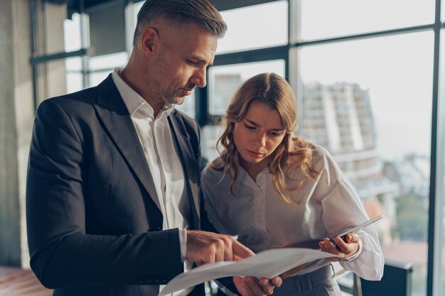 Photo two professional executives experts discussing financial accounting papers working together