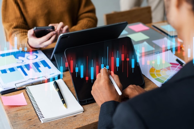 Two professional traides on technical price graph and indicator red and green candlestick chart and stock trading computer at officexAxA