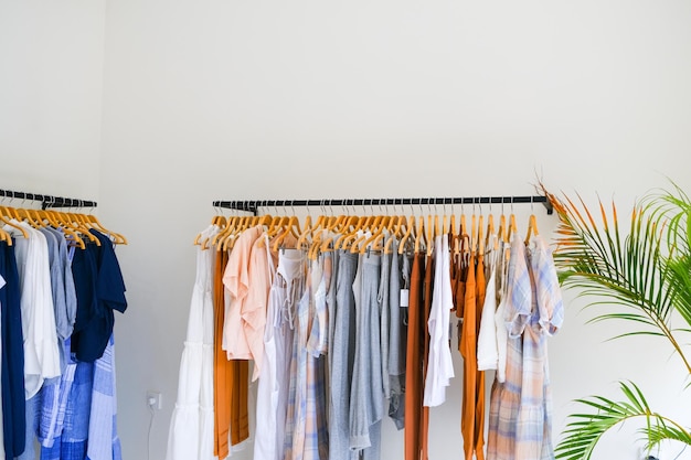 Two Racks of summer collection of natural clothes on hangers in retail fashion shop