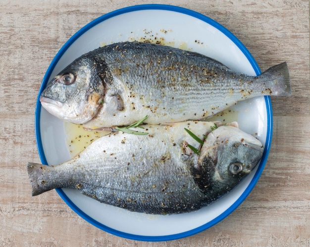 Two raw gilthead breams on a plate