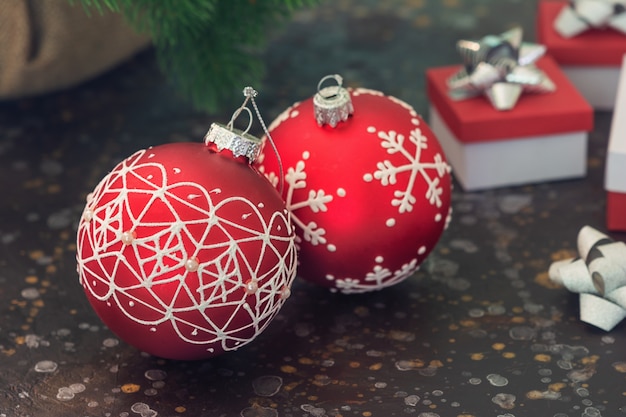 Two red Christmas ball. In the back of the wardrobe are New Year's gifts in blur. Selective focus